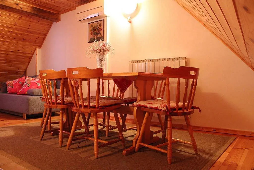 Podstrešni apartma: jedilna miza, sedežna garnitura in klimatska naprava pod lesenim stropom