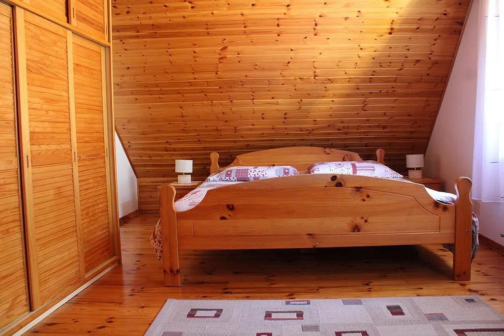 Podstrešni apartma: spalnica z leseno zakonsko posteljo in vgradno omaro